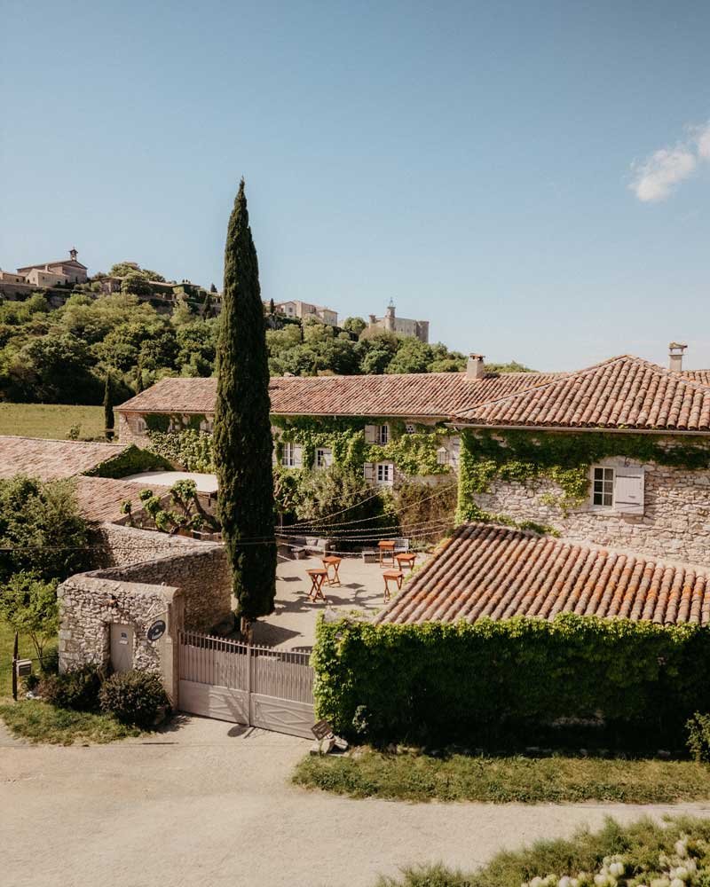 Cour intérieure en pierre du mas aménagée pour un cocktail à la Bastide de Lussan