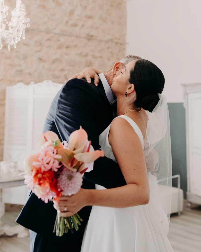 Étreinte entre la mariée et son père dans la suite nuptiale à la Bastide de Lussan