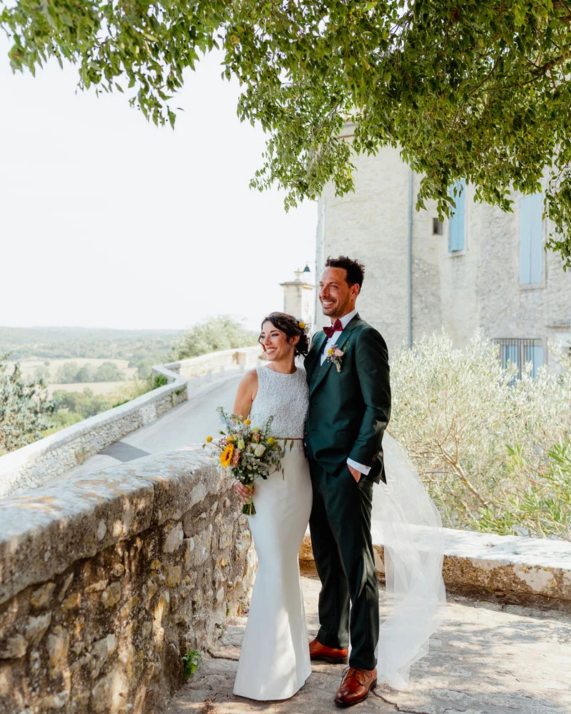 Mariés posant devant le château de Lussan avec vue sur la garrigue