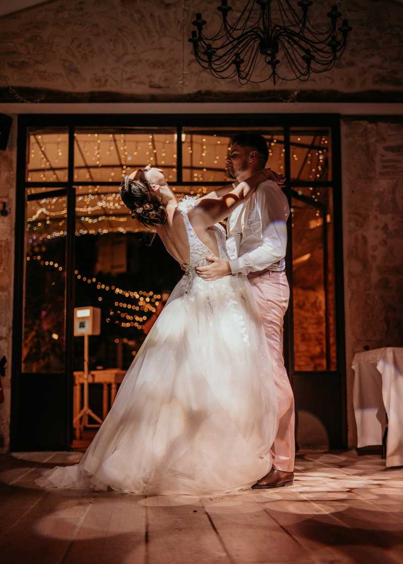 Danse des mariés sous les jeux de lumière lors de la soirée à la Bastide de Lussan