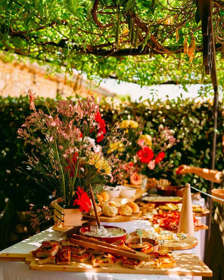 Buffet de brunch fleuri sous la pergola le lendemain du mariage à la Bastide de Lussan