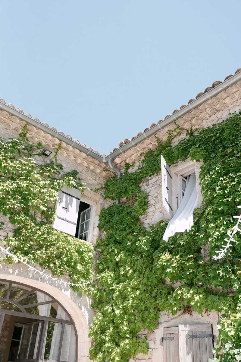 Façade de la maison principale couverte de vigne vierge à la Bastide de Lussan