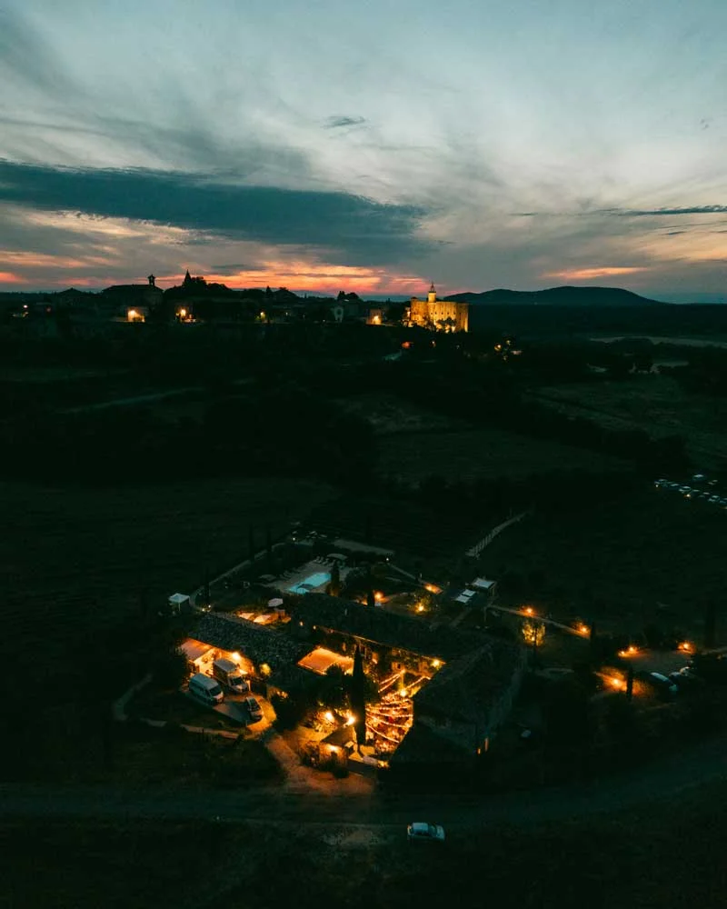 Vue aérienne nocturne de la Bastide de Lussan illuminée au coucher du soleil