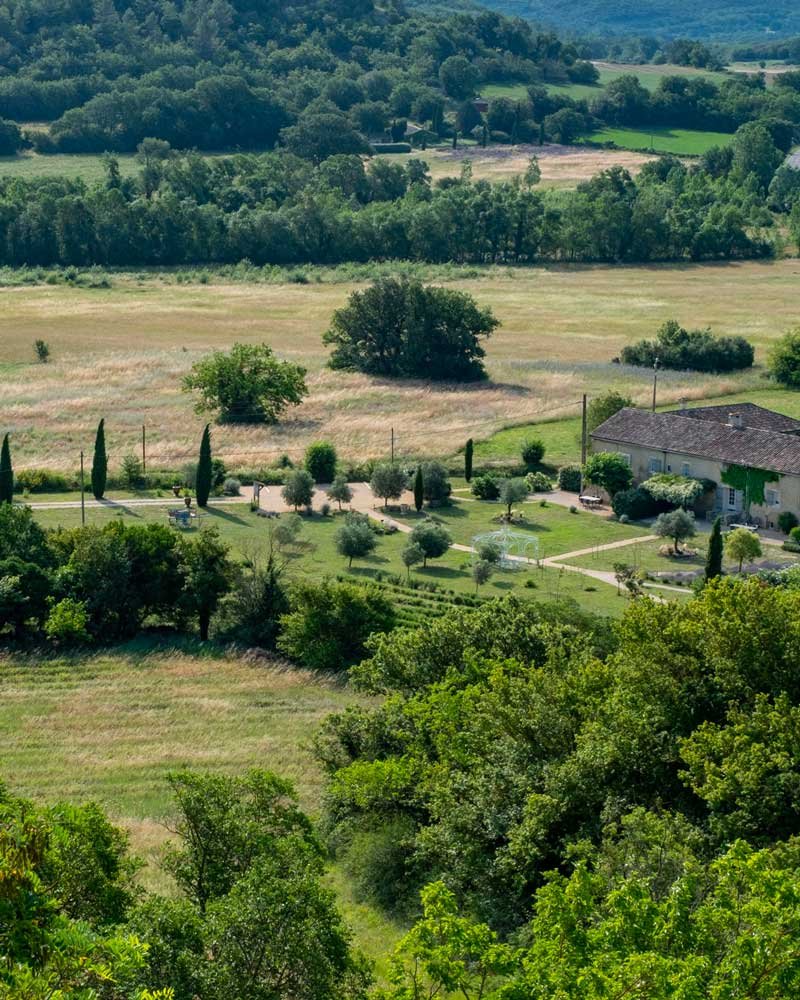 Vue de la Bastide de Lussan depuis les ramparts de Lussan. Un domaine verdoyant entouré de garrigues